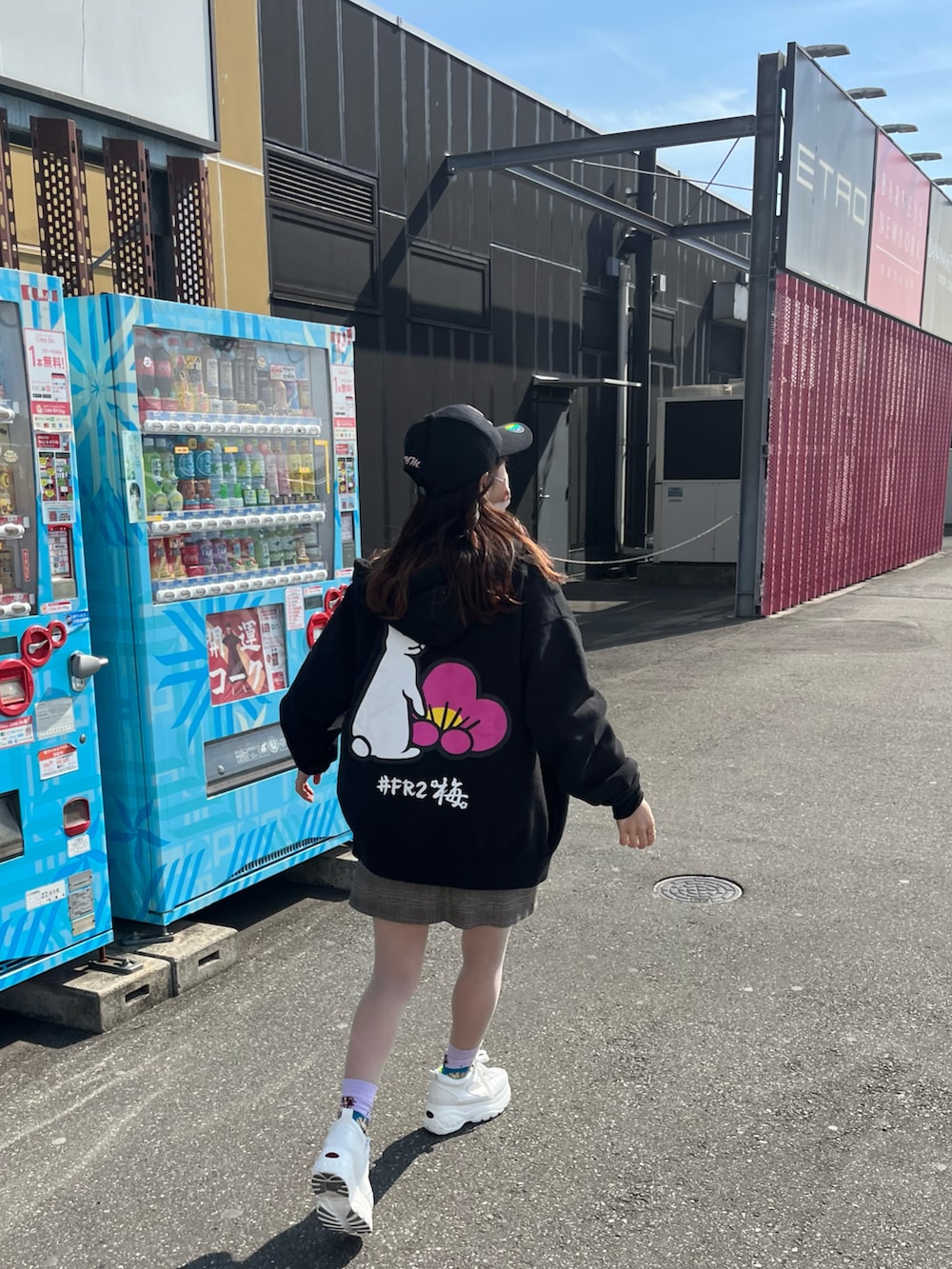 ブラック系のパーカー、ブラウン系のスカート、ホワイト系のスニーカーを着用したレディースの冬コーディネートの4枚目の写真