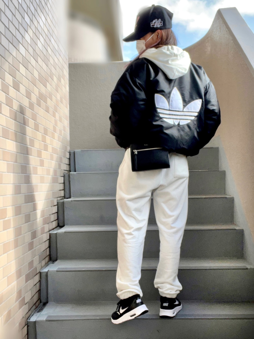 ホワイト系のパーカー、ホワイト系のスウェットパンツ、ブラック系のスニーカーを着用したレディースの冬コーディネートの2枚目の写真