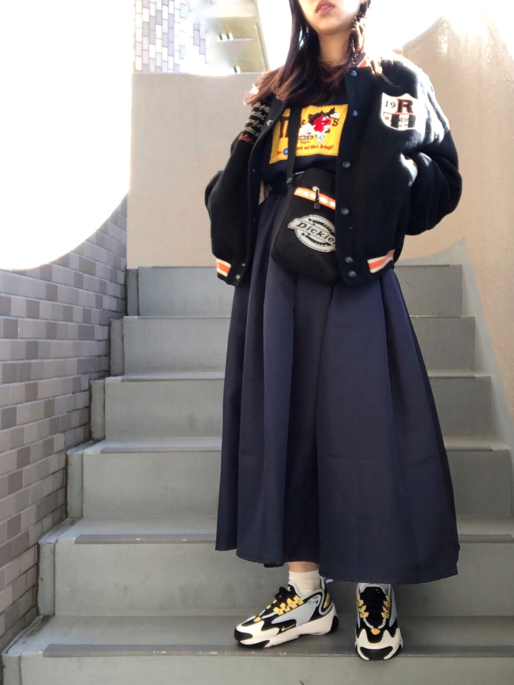 ブラック系のショルダーバッグ、ブルー系のスニーカーを着用したレディースの冬コーディネートの2枚目の写真