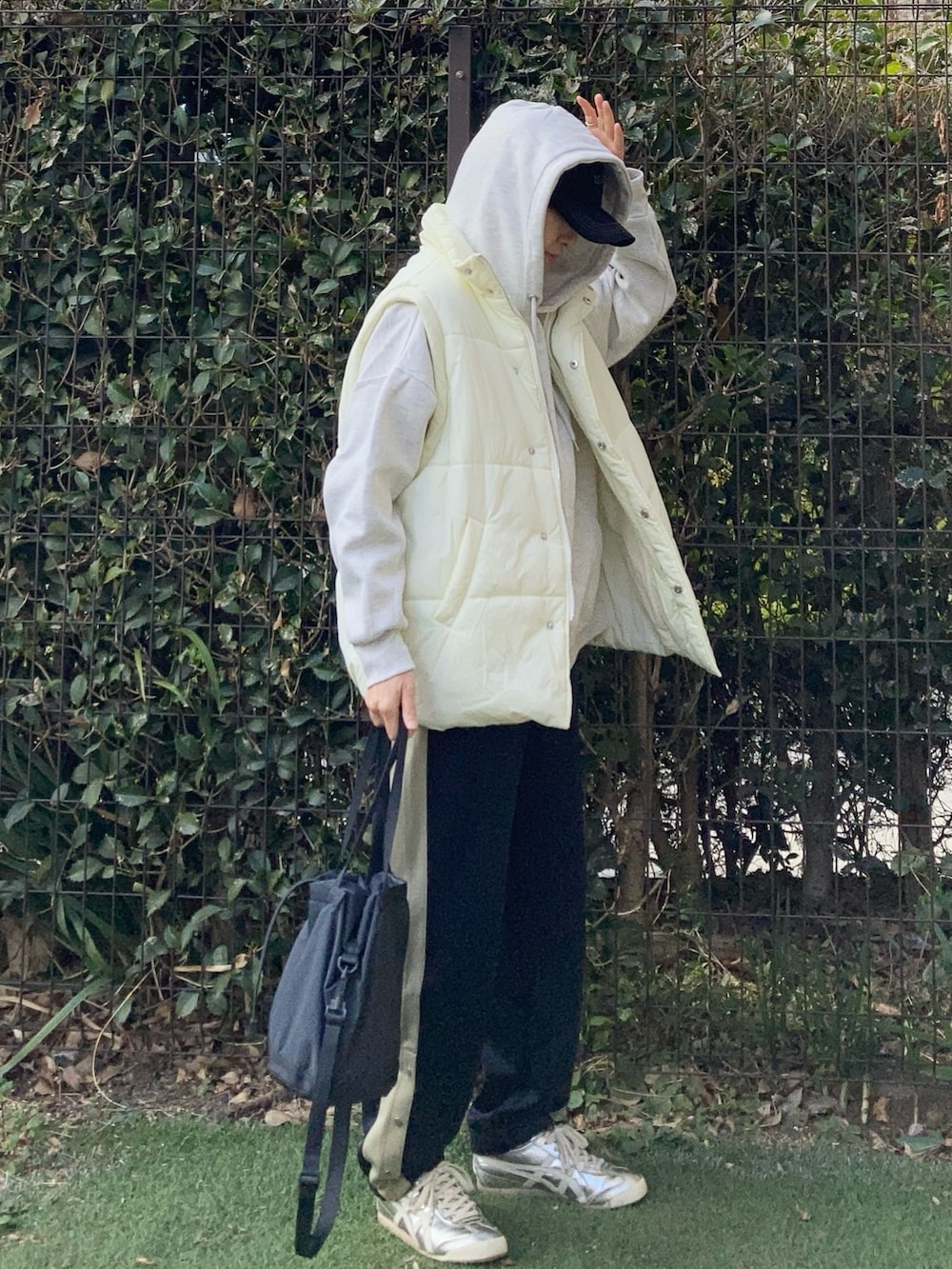 ホワイト系のダウンベスト、グレー系のパーカー、ブルー系のスウェットパンツを着用したレディースの冬コーディネートの4枚目の写真