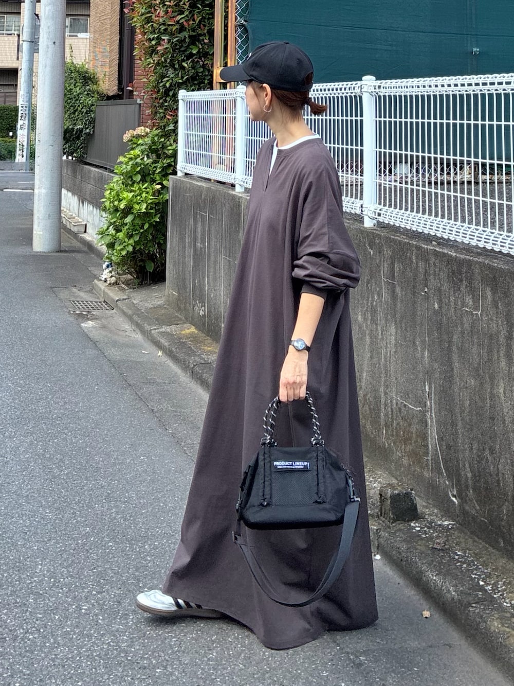 ブラウン系のワンピース、ブラック系のトートバッグ、ブラック系のキャップを着用したレディースの秋コーディネートの5枚目の写真