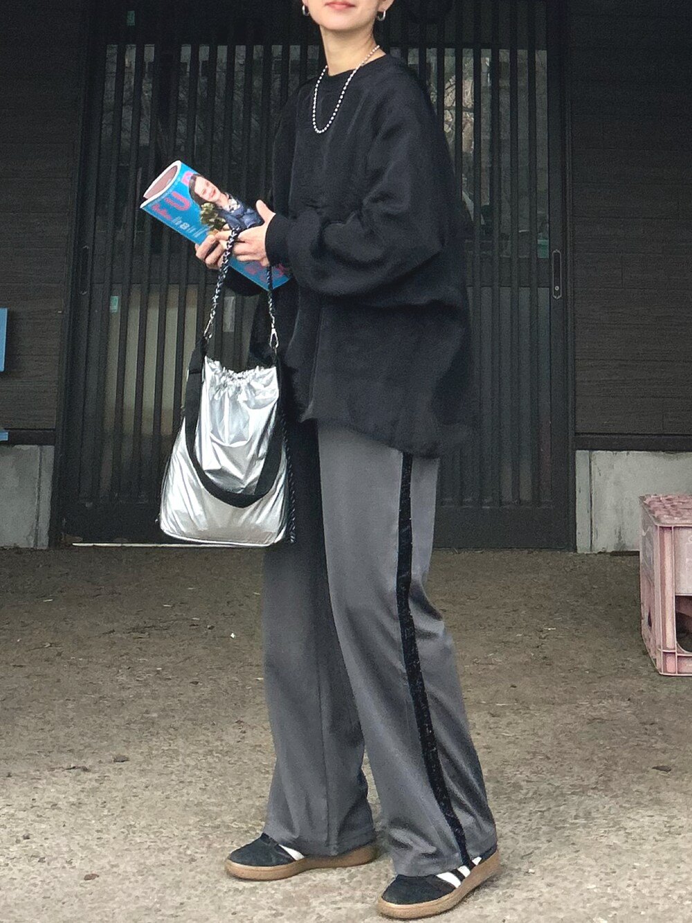 ブラック系のTシャツ/カットソー、グレー系のスラックス、シルバー系のトートバッグを着用したレディースの冬コーディネートの3枚目の写真