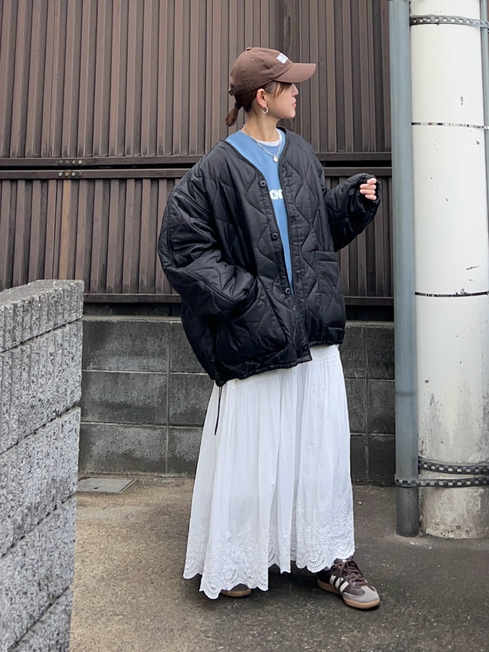 ブラック系のブルゾン、ブルー系のスウェット、ホワイト系のスカートを着用したレディースの冬コーディネートの2枚目の写真