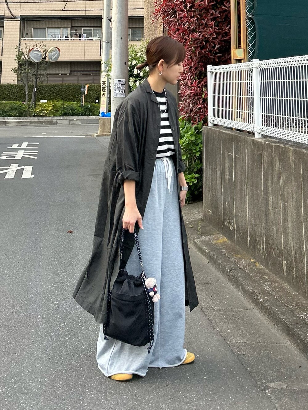 グレー系のワンピース、ブラック系のTシャツ/カットソー、ブラック系のショルダーバッグを着用したレディースの春コーディネートの3枚目の写真