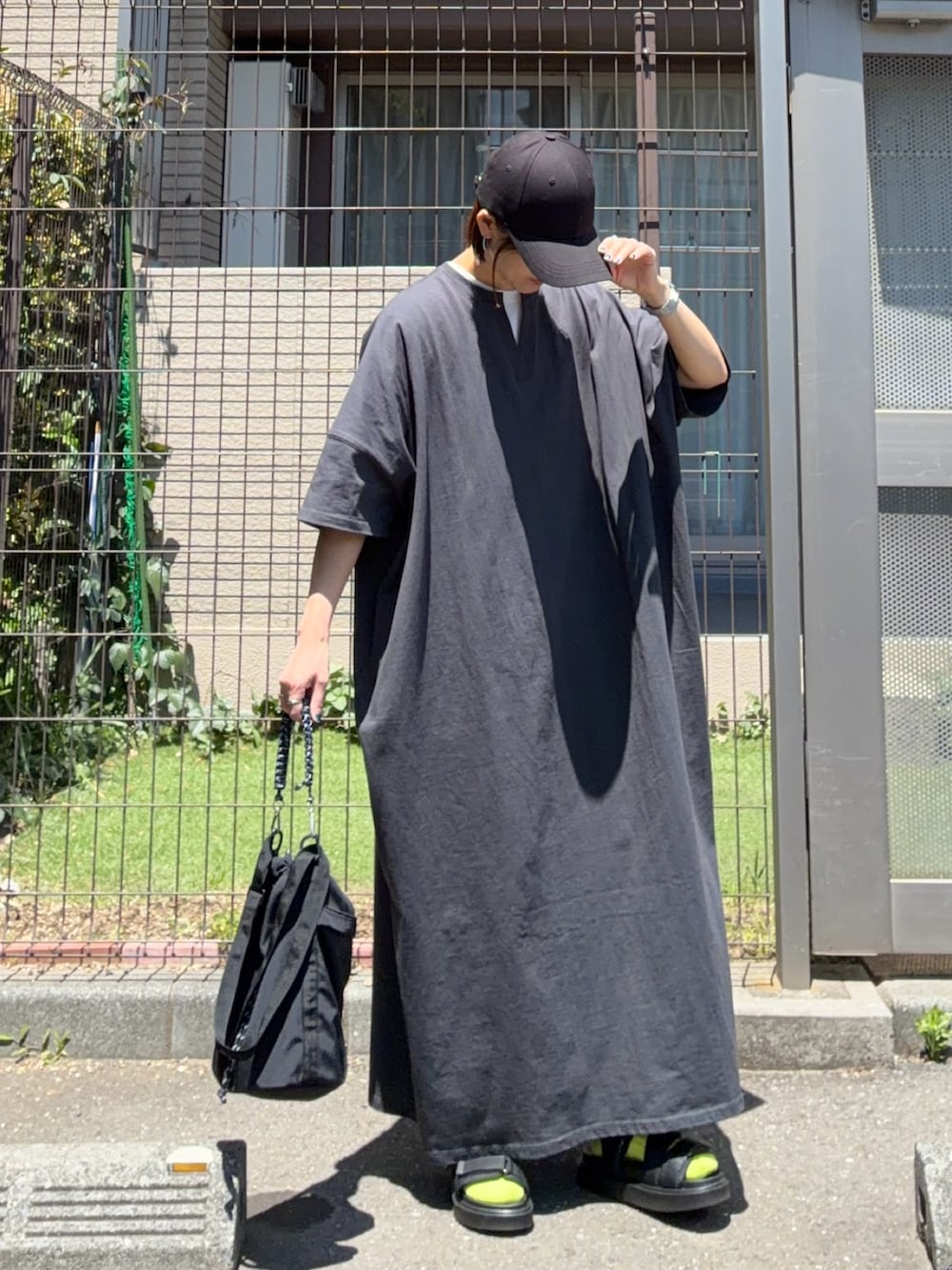 グレー系のワンピース、ブラック系のショルダーバッグ、グリーン系のソックス/靴下を着用したレディースの春コーディネートの2枚目の写真