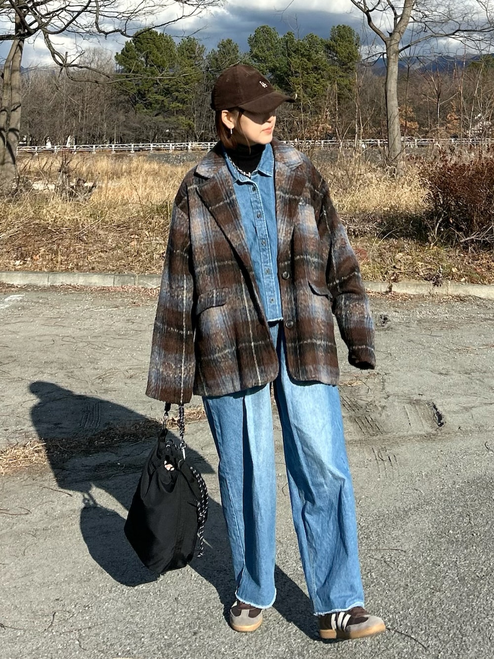 ブルー系のシャツ/ブラウス、ブルー系のデニムパンツ、ブラウン系のテーラードジャケットを着用したレディースの冬コーディネートの3枚目の写真