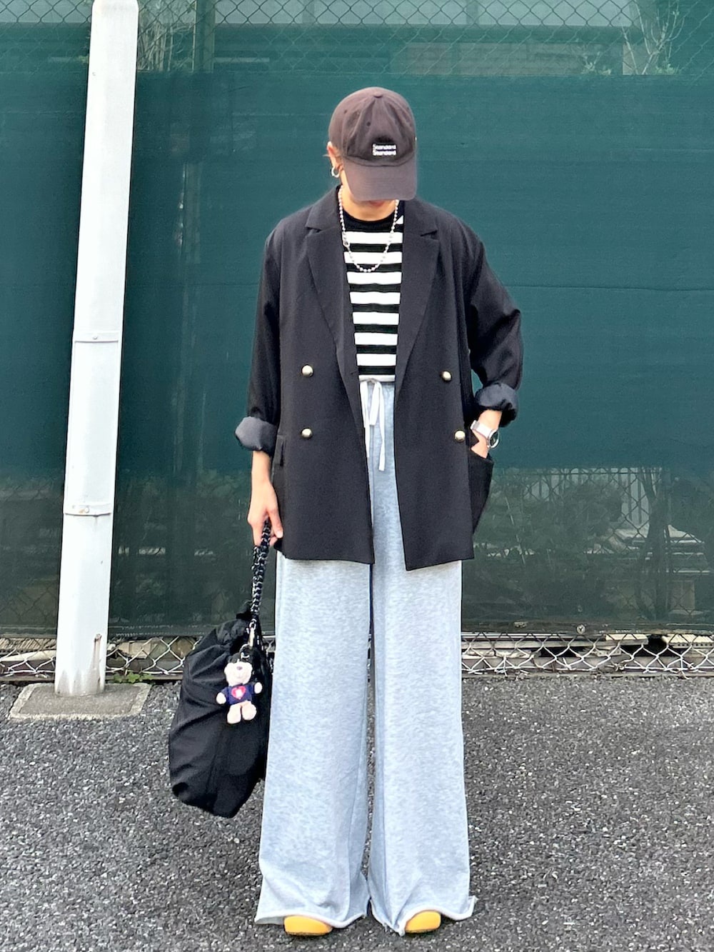 ブラック系のTシャツ/カットソー、ブラック系のテーラードジャケット、ブラック系のトートバッグを着用したレディースの春コーディネートの3枚目の写真