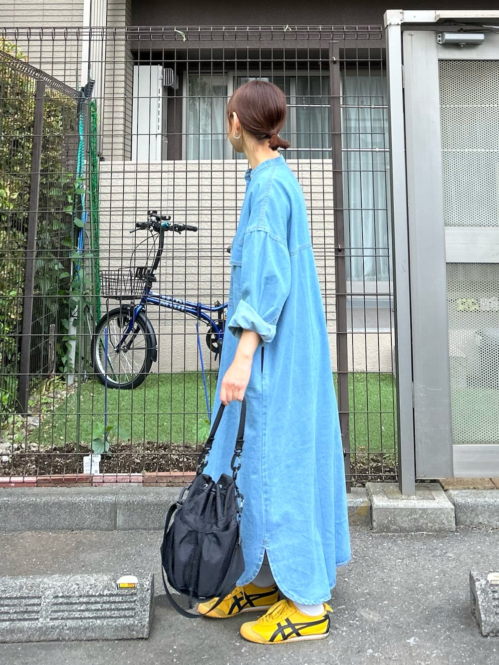 ブルー系のワンピース、ブラック系のショルダーバッグを着用したレディースの春コーディネートの2枚目の写真