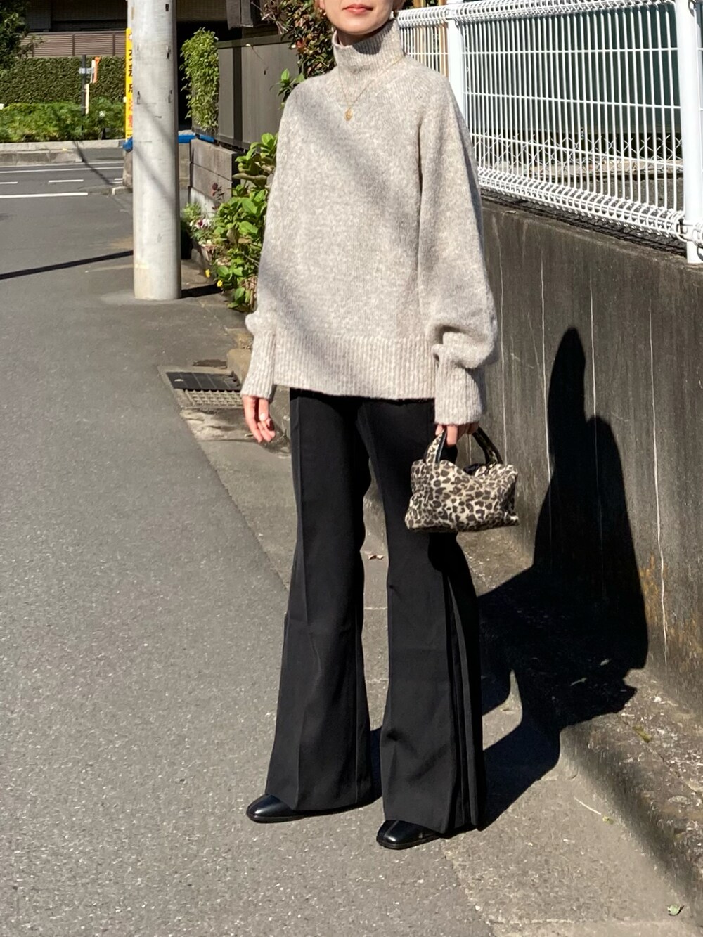 ホワイト系のニット/セーター、ブラック系のその他パンツ、ブラック系のブーツを着用したレディースの秋コーディネートの3枚目の写真