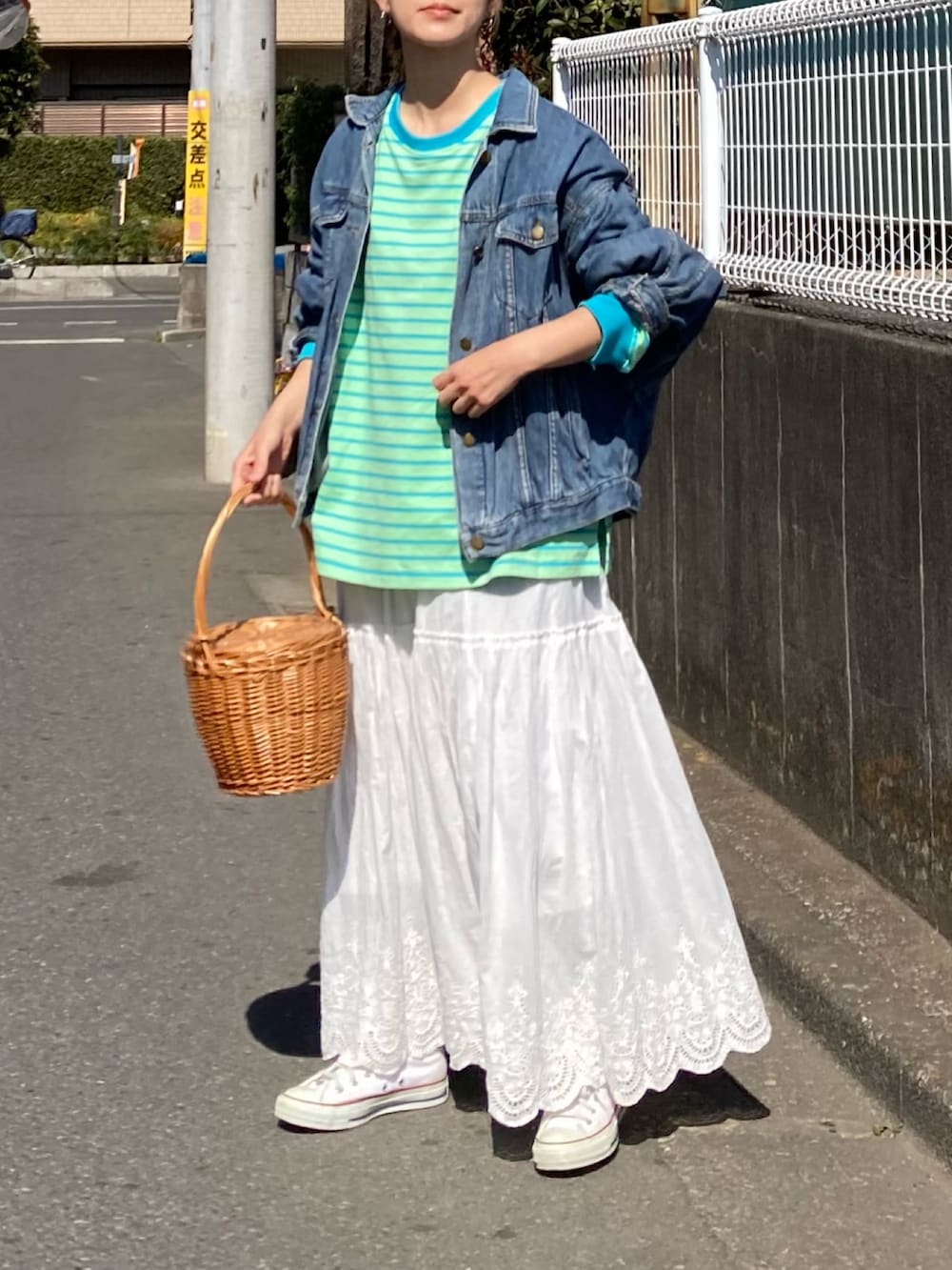 グリーン系のTシャツ/カットソー、ホワイト系のスカート、ホワイト系のスニーカーを着用したレディースの春コーディネートの4枚目の写真