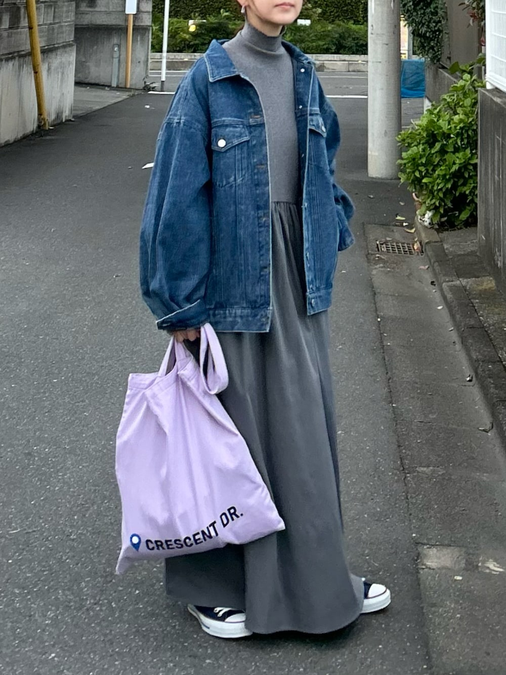 グレー系のワンピース、パープル系のトートバッグ、ブルー系のデニムジャケットを着用したレディースの冬コーディネートの4枚目の写真