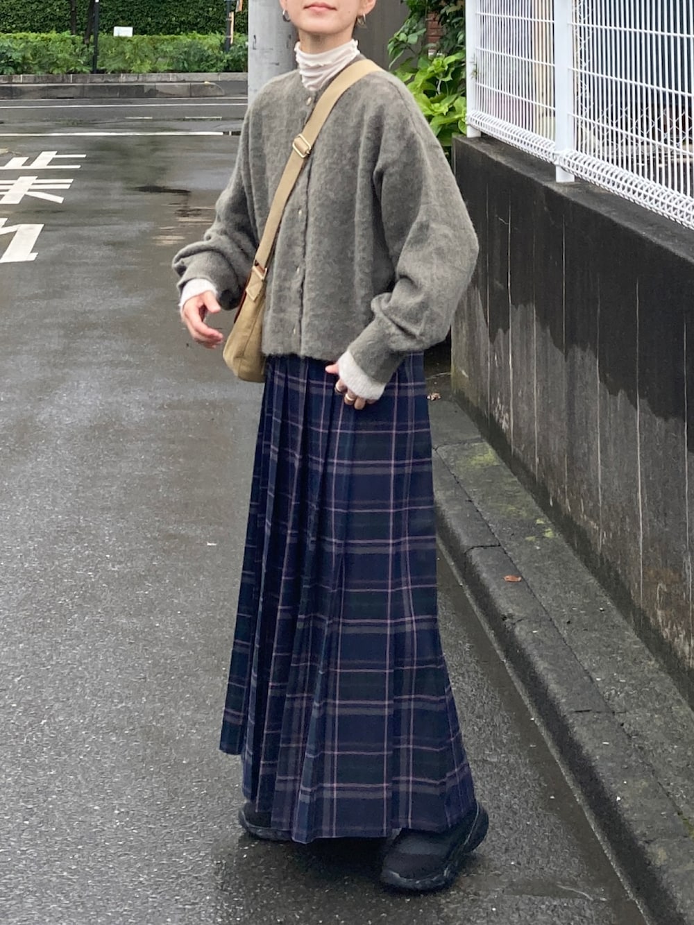 グリーン系のカーディガン/ボレロ、ブルー系のスカート、ブラック系のブーツを着用したレディースの秋コーディネートの2枚目の写真