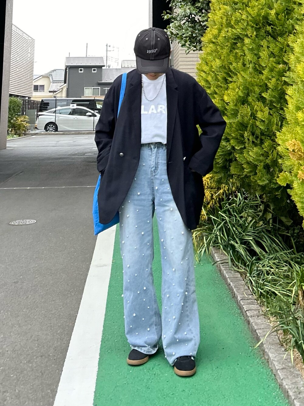 ホワイト系のTシャツ/カットソー、ブルー系のテーラードジャケット、ブルー系のデニムパンツを着用したレディースの春コーディネートの4枚目の写真