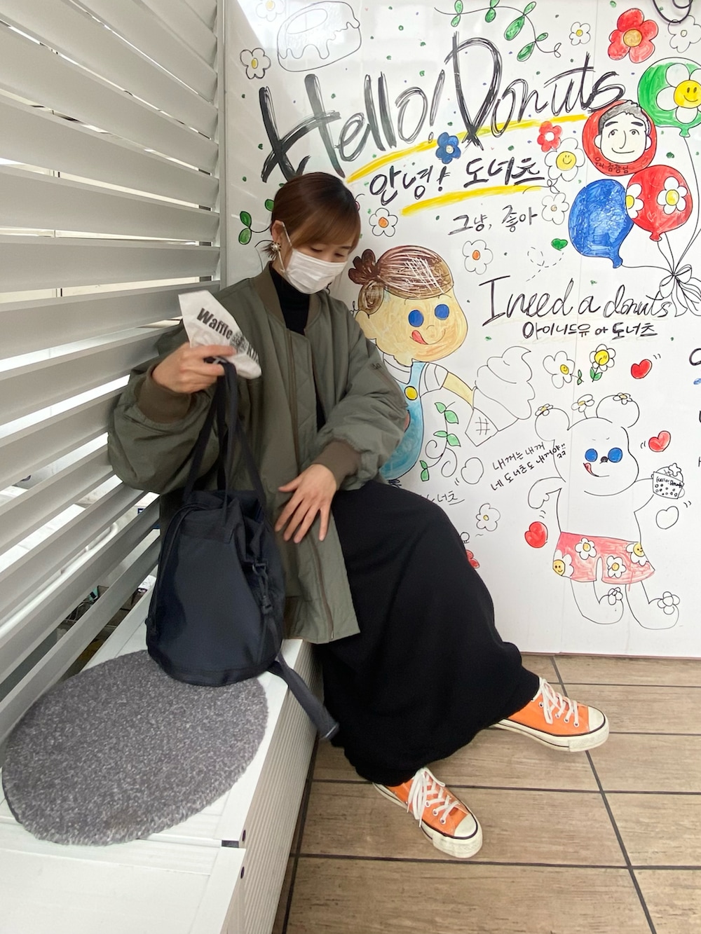 グリーン系のMA-1、ブラック系のワンピース、ブラック系のバッグを着用したレディースの春コーディネートの2枚目の写真