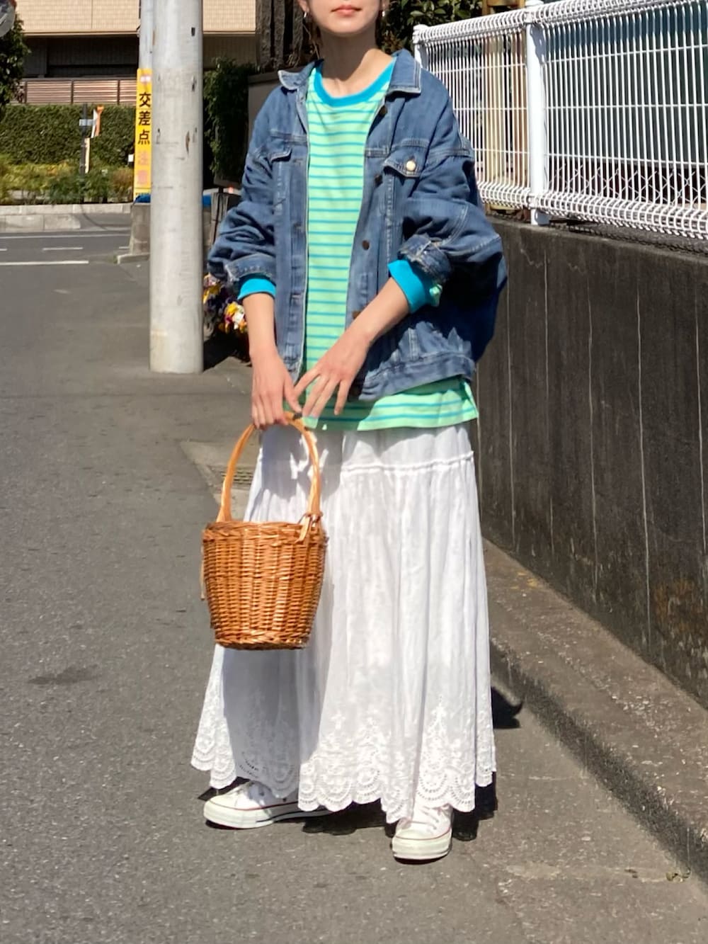 グリーン系のTシャツ/カットソー、ホワイト系のスカート、ホワイト系のスニーカーを着用したレディースの春コーディネートの2枚目の写真