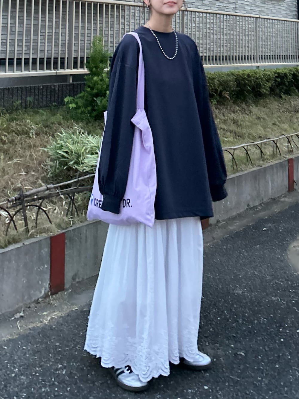 ブルー系のTシャツ/カットソー、ホワイト系のスカート、パープル系のトートバッグを着用したレディースの秋コーディネートの3枚目の写真