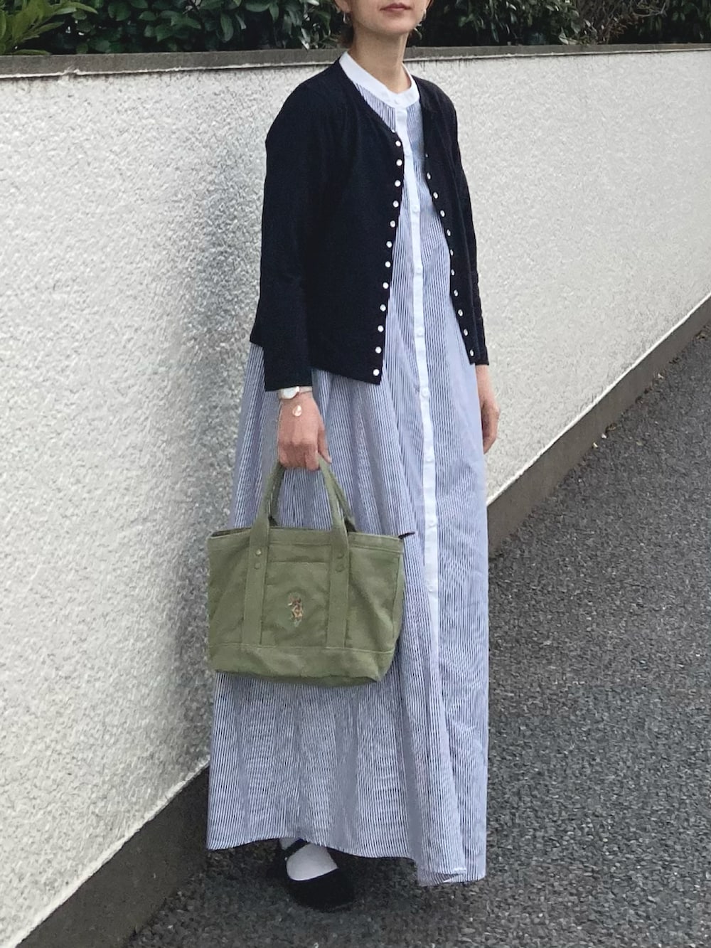 ブラック系のカーディガン/ボレロ、ブラック系のワンピース、グリーン系のトートバッグを着用したレディースの春コーディネートの2枚目の写真