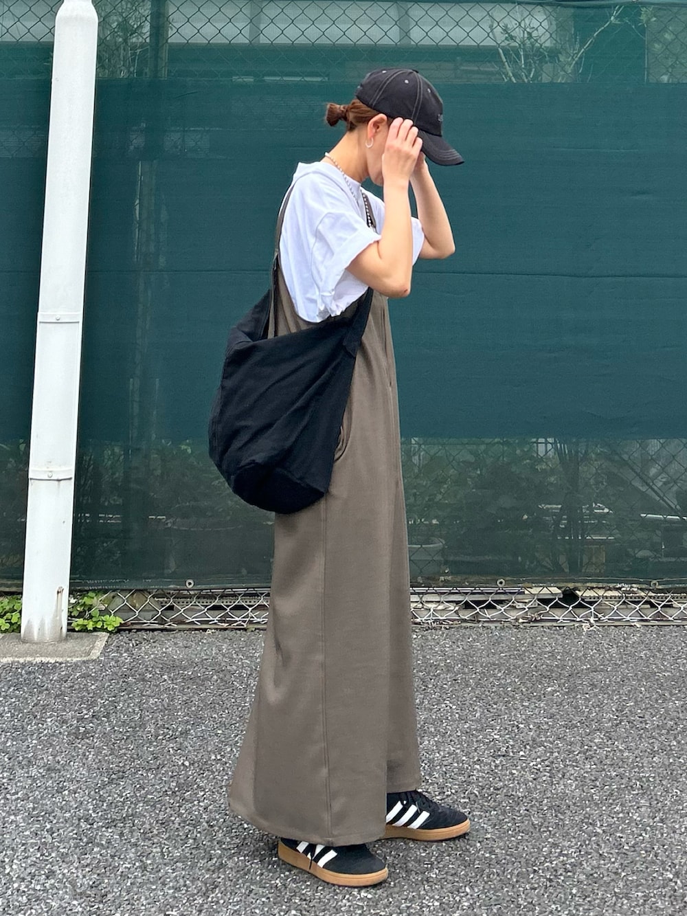 ベージュ系のワンピース、ホワイト系のTシャツ/カットソー、ブラック系のショルダーバッグを着用したレディースの春コーディネートの5枚目の写真