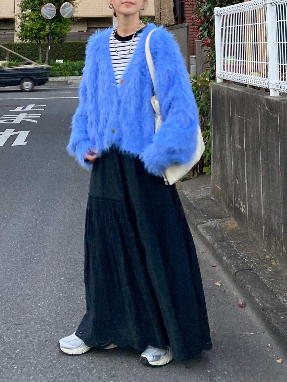 ブルー系のニット/セーター、ブラック系のTシャツ/カットソー、ブラック系のスカートを着用したレディースの秋コーディネートの2枚目の写真