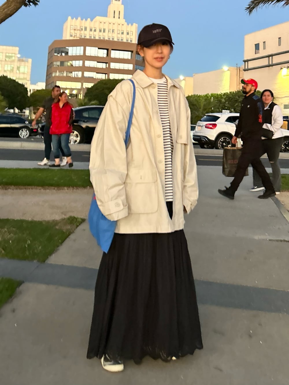 ホワイト系のブルゾン、ホワイト系のTシャツ/カットソー、ブラック系のスカートを着用したレディースの冬コーディネートの3枚目の写真