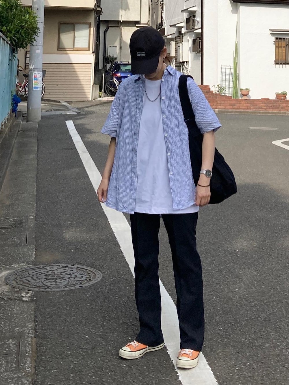 ブルー系のシャツ/ブラウス、ホワイト系のTシャツ/カットソー、ブラック系のショルダーバッグを着用したレディースの春コーディネートの2枚目の写真