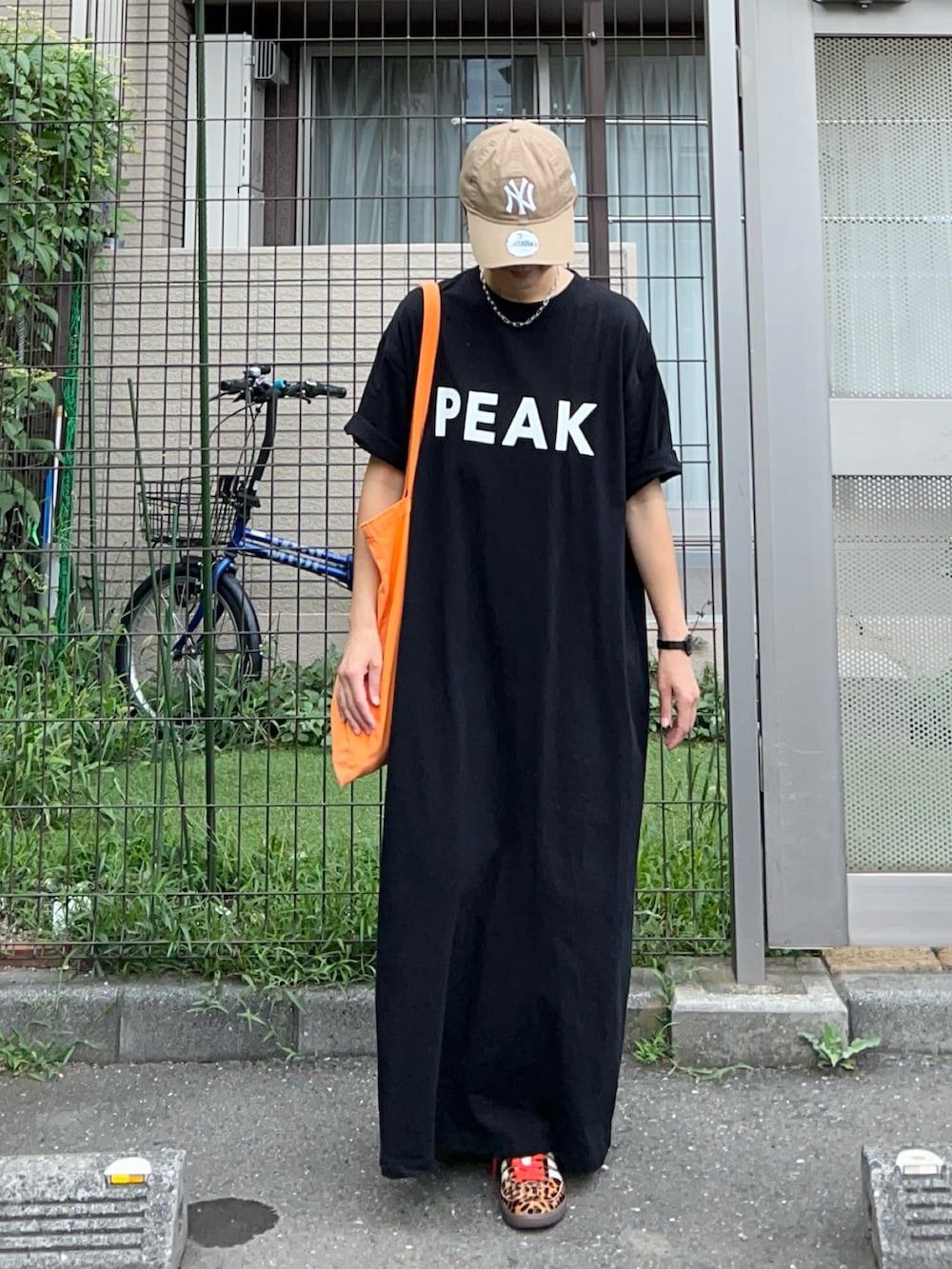 ブラック系のワンピース、オレンジ系のトートバッグ、ブラック系のスニーカーを着用したレディースの夏コーディネートの4枚目の写真