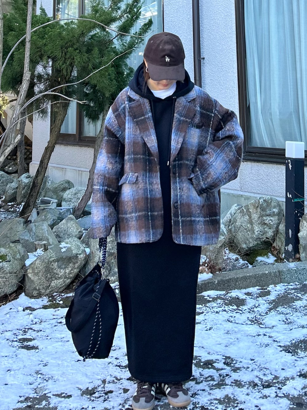 ブラック系のワンピース、ブラウン系のテーラードジャケット、ブラック系のトートバッグを着用したレディースの冬コーディネートの2枚目の写真