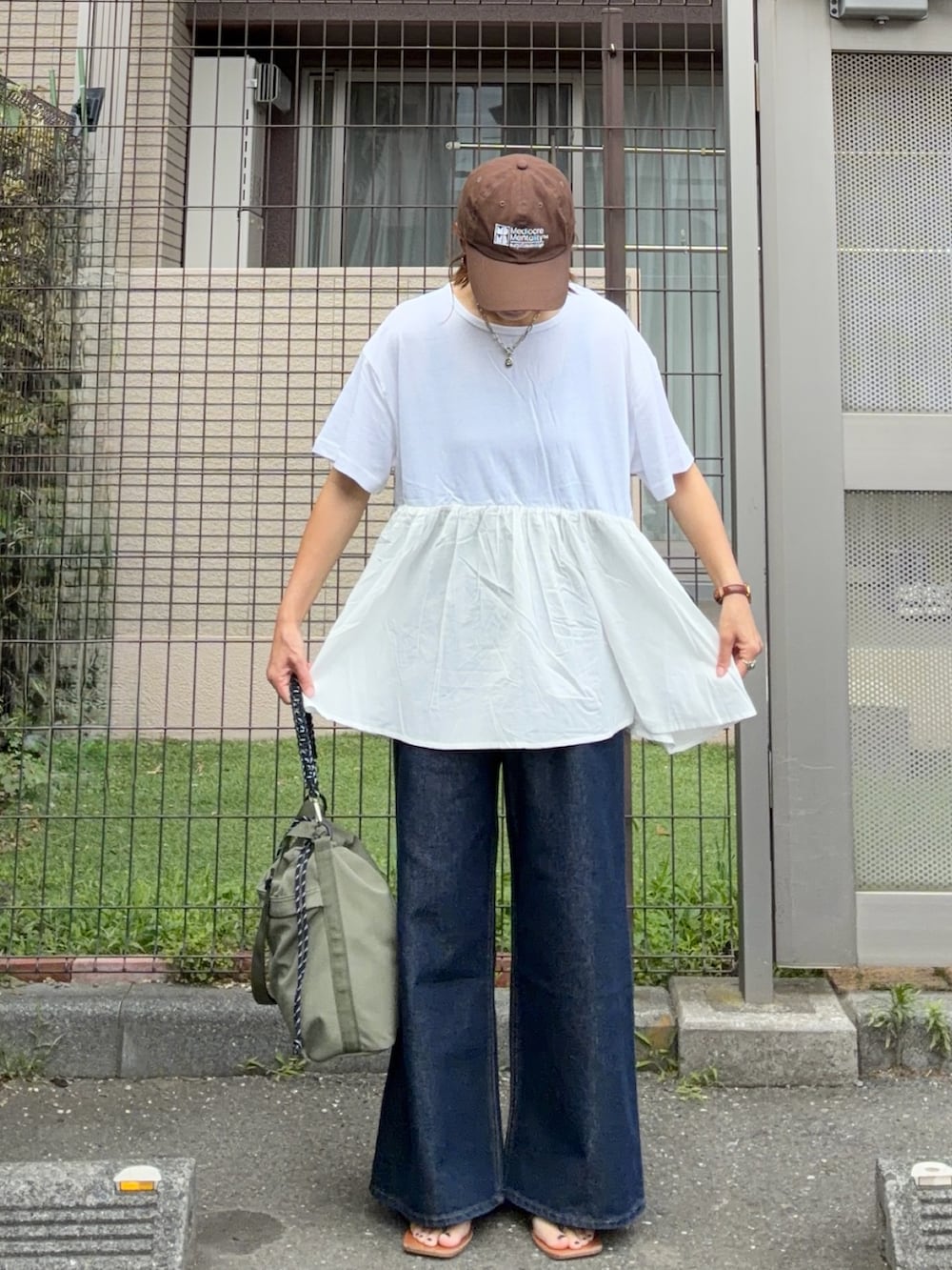 ホワイト系のTシャツ/カットソー、ブルー系のデニムパンツ、グリーン系のショルダーバッグを着用したレディースの夏コーディネートの2枚目の写真