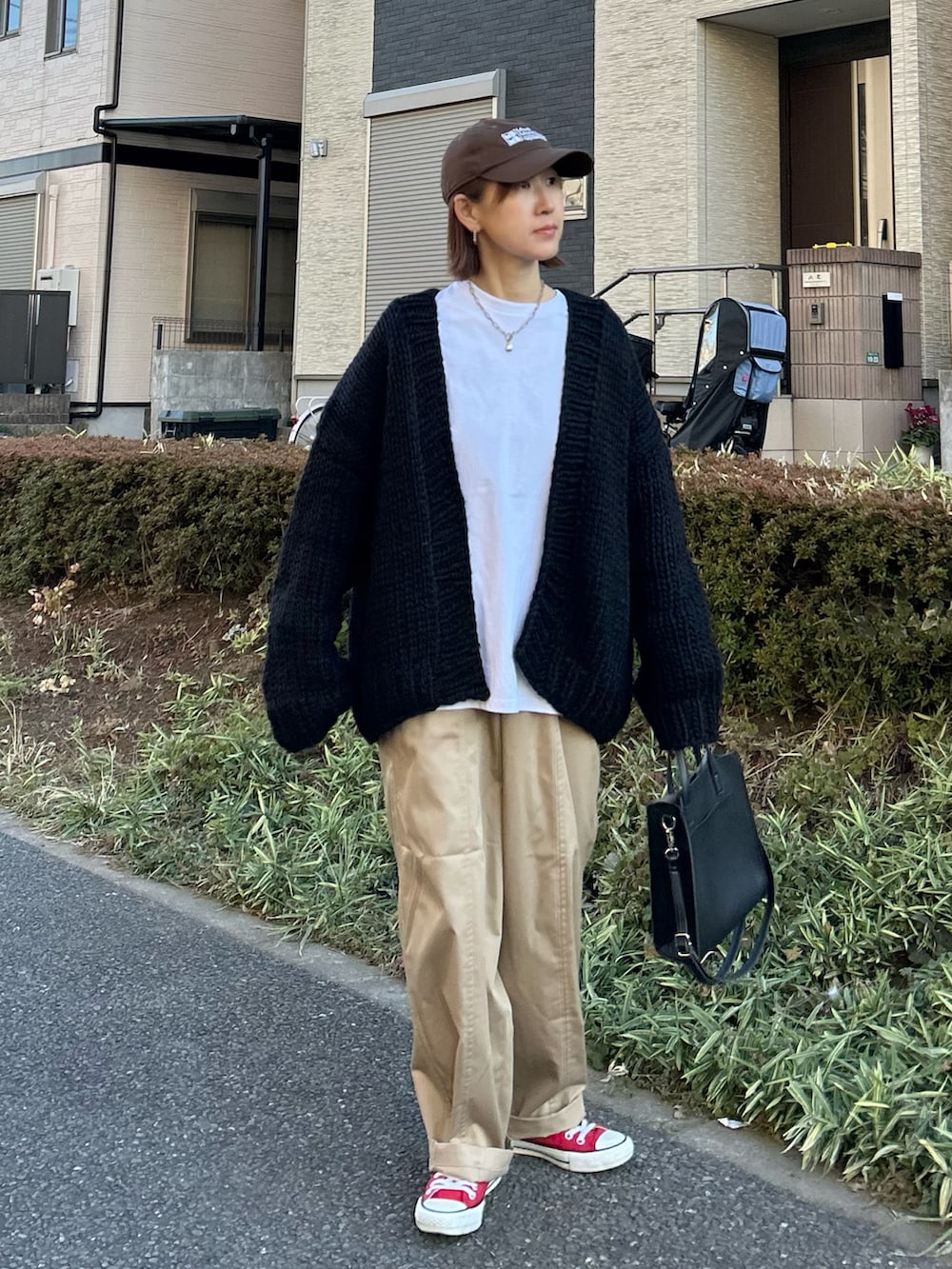 ベージュ系のチノパンツ、ブラック系のショルダーバッグ、レッド系のスニーカーを着用したレディースの冬コーディネートの2枚目の写真