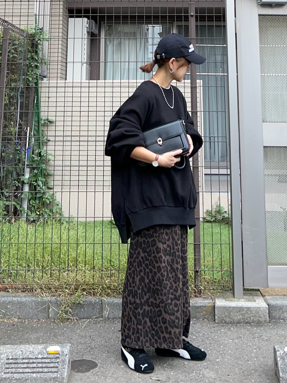 ブラック系のスウェット、ブラウン系のスカート、ブラック系のハンドバッグを着用したレディースの冬コーディネートの3枚目の写真