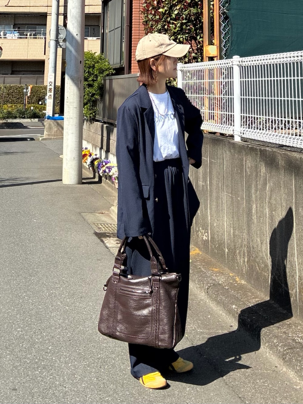 ブルー系のテーラードジャケット、ブルー系のスラックス、ブラウン系のトートバッグを着用したレディースの春コーディネートの4枚目の写真