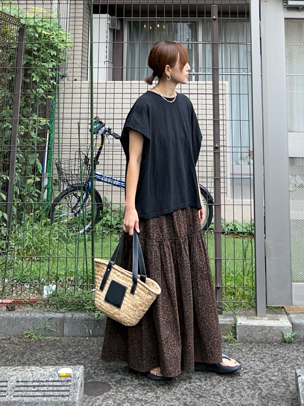 ブラック系のTシャツ/カットソー、ブラウン系のスカート、ブラック系のかごバッグを着用したレディースの夏コーディネートの2枚目の写真