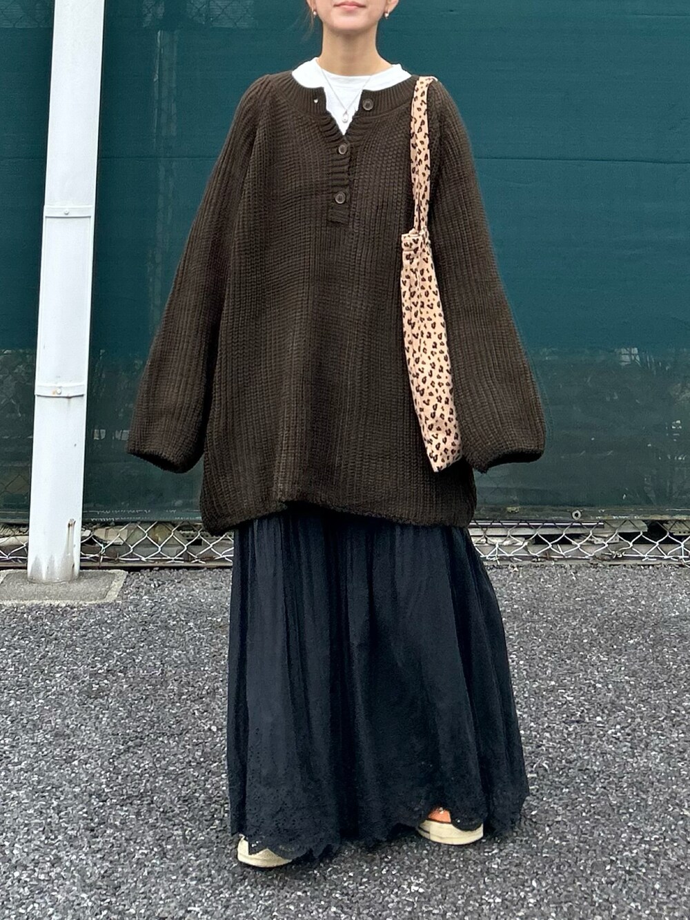 ブラウン系のニット/セーター、ブラック系のスカートを着用したレディースの冬コーディネートの2枚目の写真