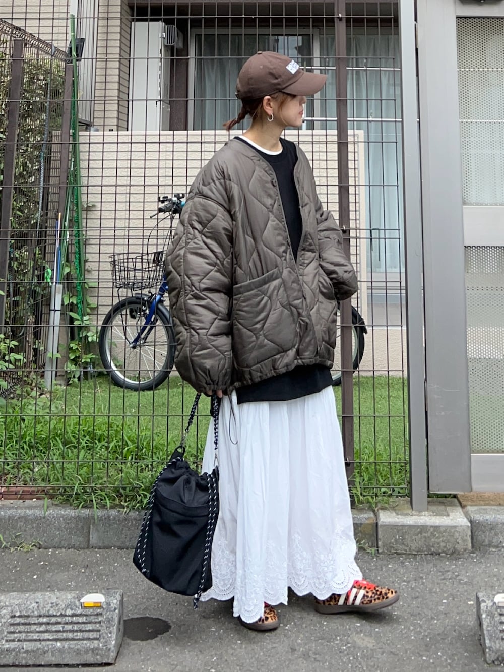 ホワイト系のスカート、ブラック系のトートバッグ、ブラック系のスウェットを着用したレディースの秋コーディネートの3枚目の写真