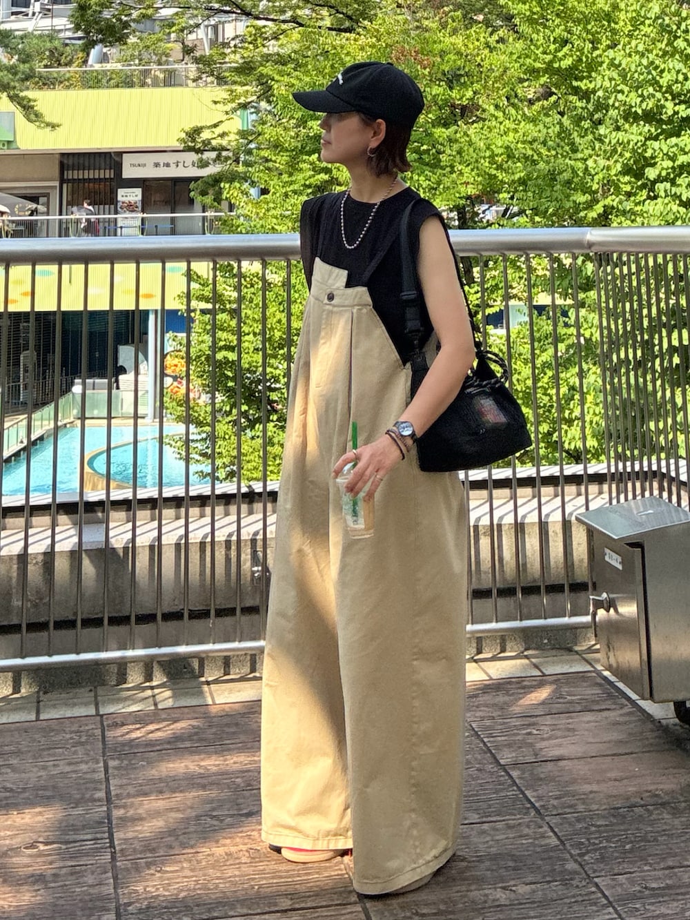 ブラック系のTシャツ/カットソー、ベージュ系のサロペット/オーバーオール、ブラック系のトートバッグを着用したレディースの夏コーディネートの2枚目の写真