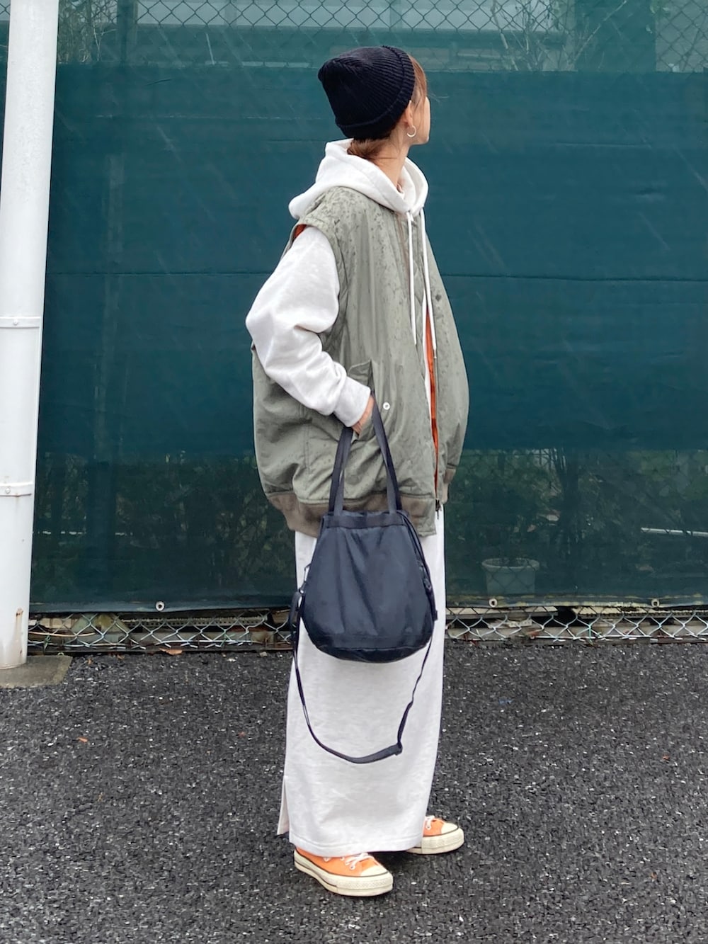 グレー系のワンピース、グリーン系のMA-1、ブラック系のニットキャップ/ビーニーを着用したレディースの秋コーディネートの4枚目の写真