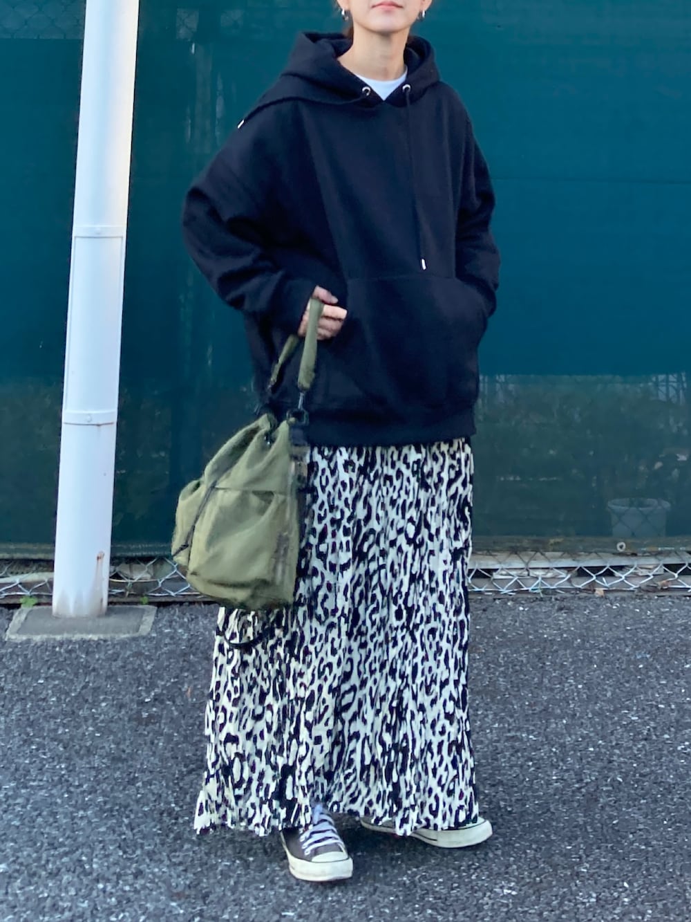 ブラック系のパーカー、ベージュ系のスカート、ブラック系のトートバッグを着用したレディースの秋コーディネートの4枚目の写真