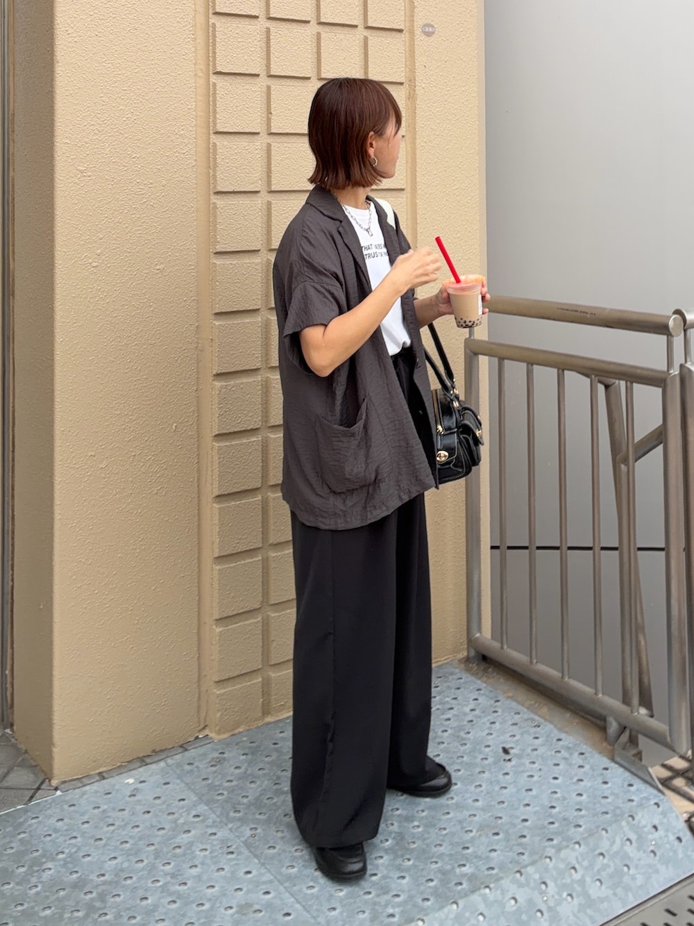ホワイト系のTシャツ/カットソー、グレー系のテーラードジャケット、ブラック系のスラックスを着用したレディースの夏コーディネートの2枚目の写真