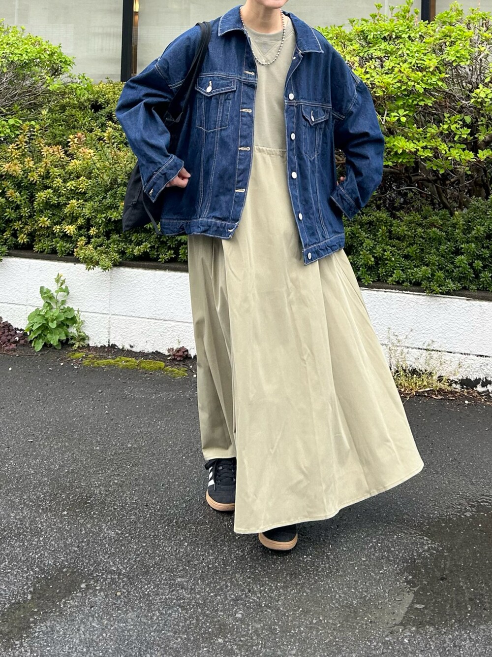 グリーン系のワンピース、ブラック系のトートバッグ、ブルー系のデニムジャケットを着用したレディースの春コーディネートの5枚目の写真