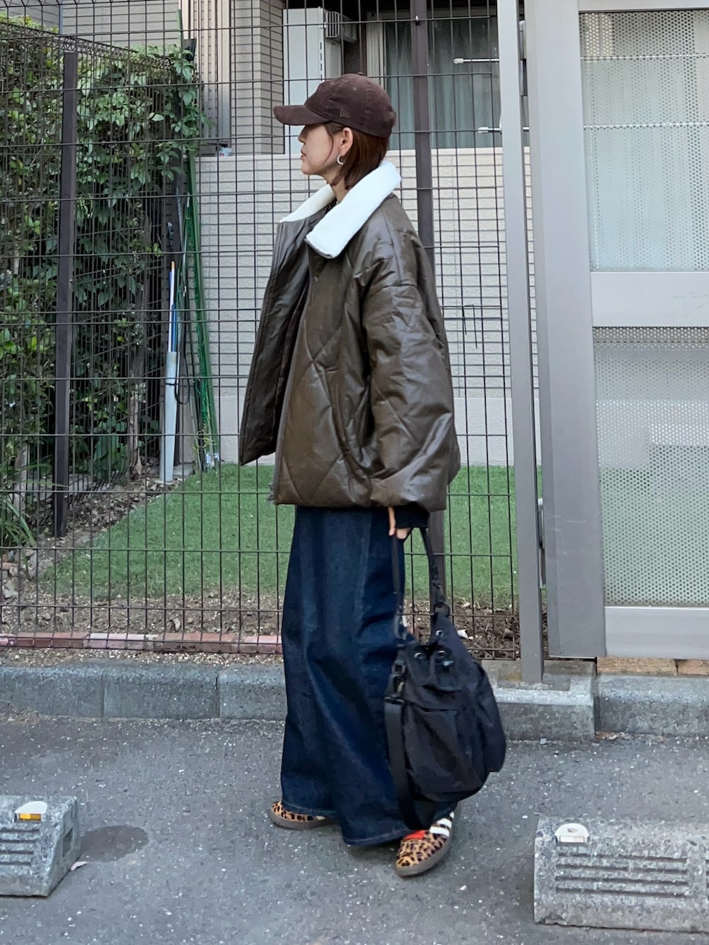 ブラウン系のダウンジャケット/コート、ブラック系のニット/セーター、ブラック系のショルダーバッグを着用したレディースの秋コーディネートの2枚目の写真