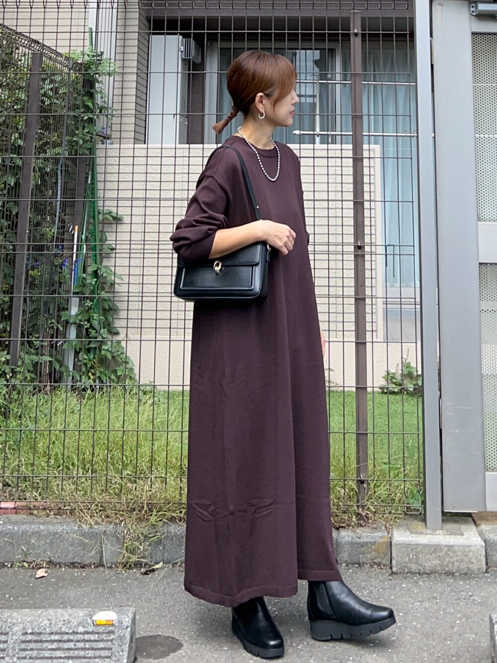 ブラウン系のワンピース、ブラック系のハンドバッグ、ブラック系のシューズを着用したレディースの秋コーディネートの2枚目の写真