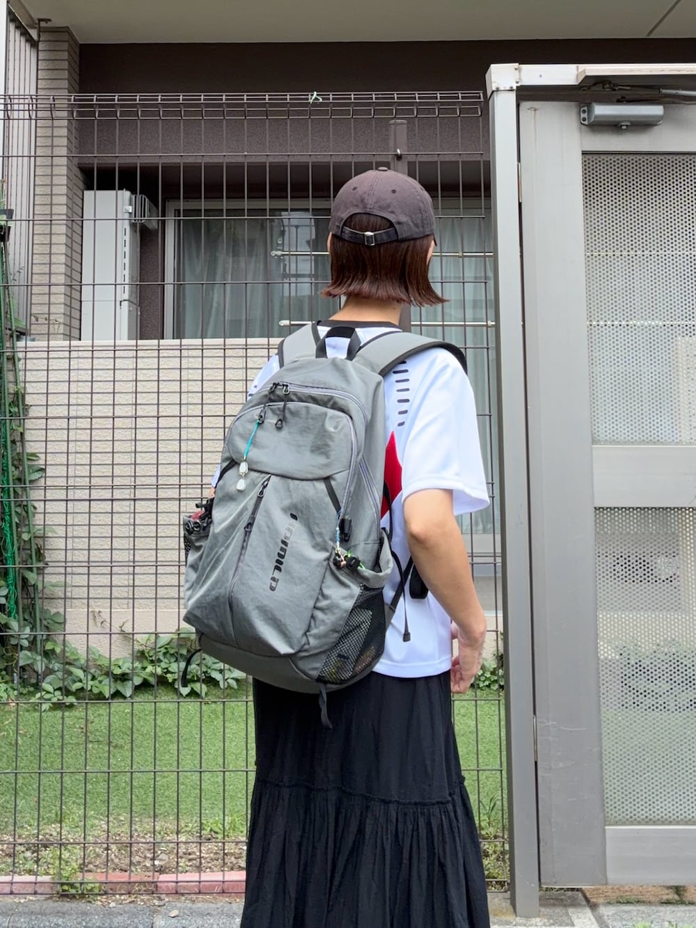 グレー系のバックパック/リュック、ホワイト系のトップス、ブラック系のスカートを着用したレディースの春コーディネートの4枚目の写真