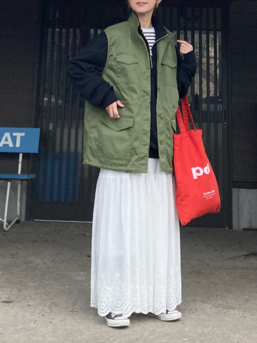 ブラック系のスウェット、グリーン系のベスト、ホワイト系のスカートを着用したレディースの冬コーディネートの4枚目の写真