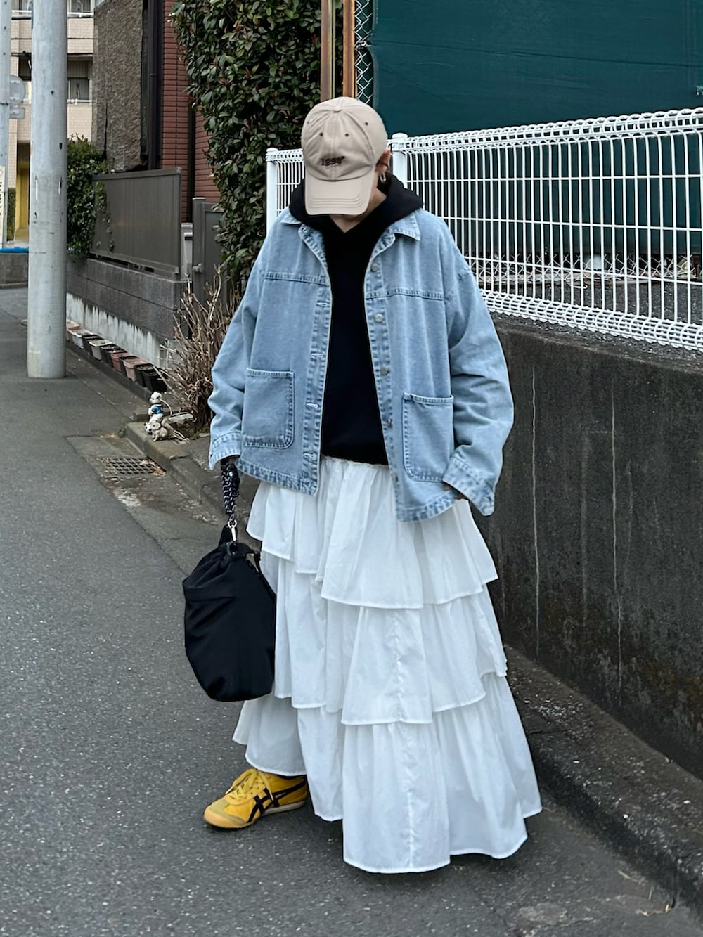 ブルー系のデニムジャケット、ブラック系のスウェット、ホワイト系のスカートを着用したレディースの春コーディネートの2枚目の写真