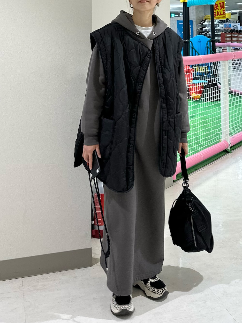 ブラック系のブルゾン、グレー系のワンピース、ブラック系のショルダーバッグを着用したレディースの冬コーディネートの3枚目の写真