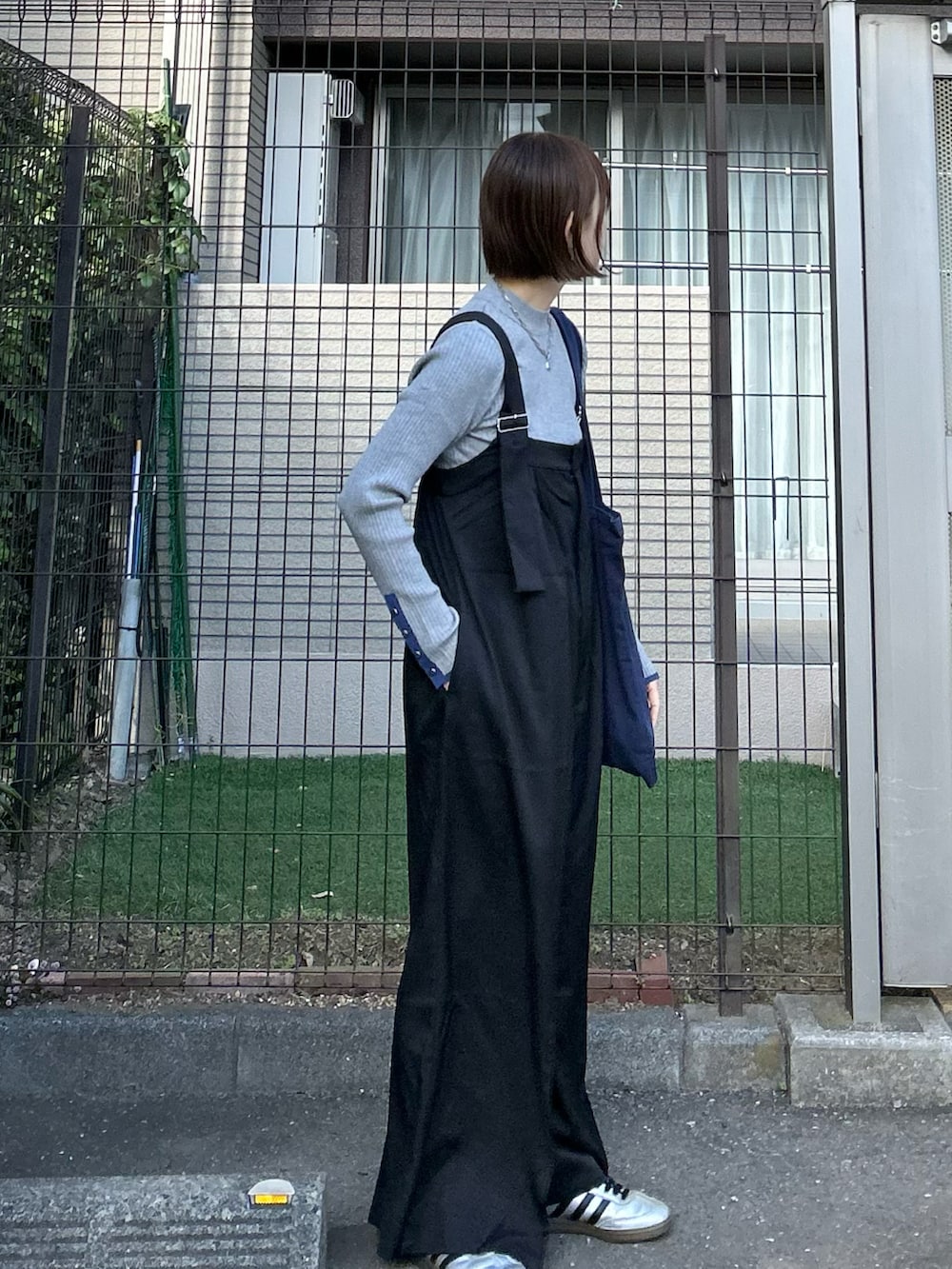 ブラック系のサロペット/オーバーオール、ブルー系のトートバッグ、グレー系のニット/セーターを着用したレディースの冬コーディネートの2枚目の写真