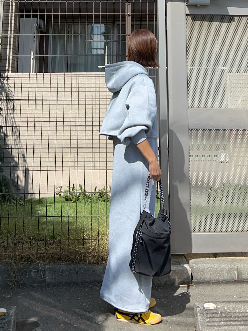 ブラック系のトートバッグ、グレー系のワンピースを着用したレディースの秋コーディネートの2枚目の写真