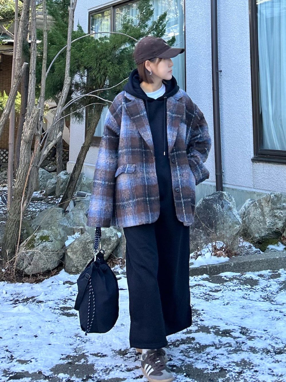 ブラック系のワンピース、ブラウン系のテーラードジャケット、ブラック系のトートバッグを着用したレディースの冬コーディネートの3枚目の写真