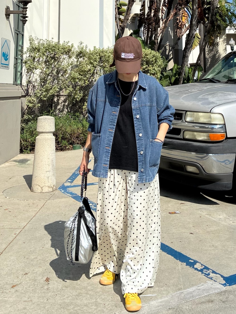 ブルー系のデニムジャケット、ブラック系のTシャツ/カットソー、ホワイト系のスラックスを着用したレディースの春コーディネートの3枚目の写真