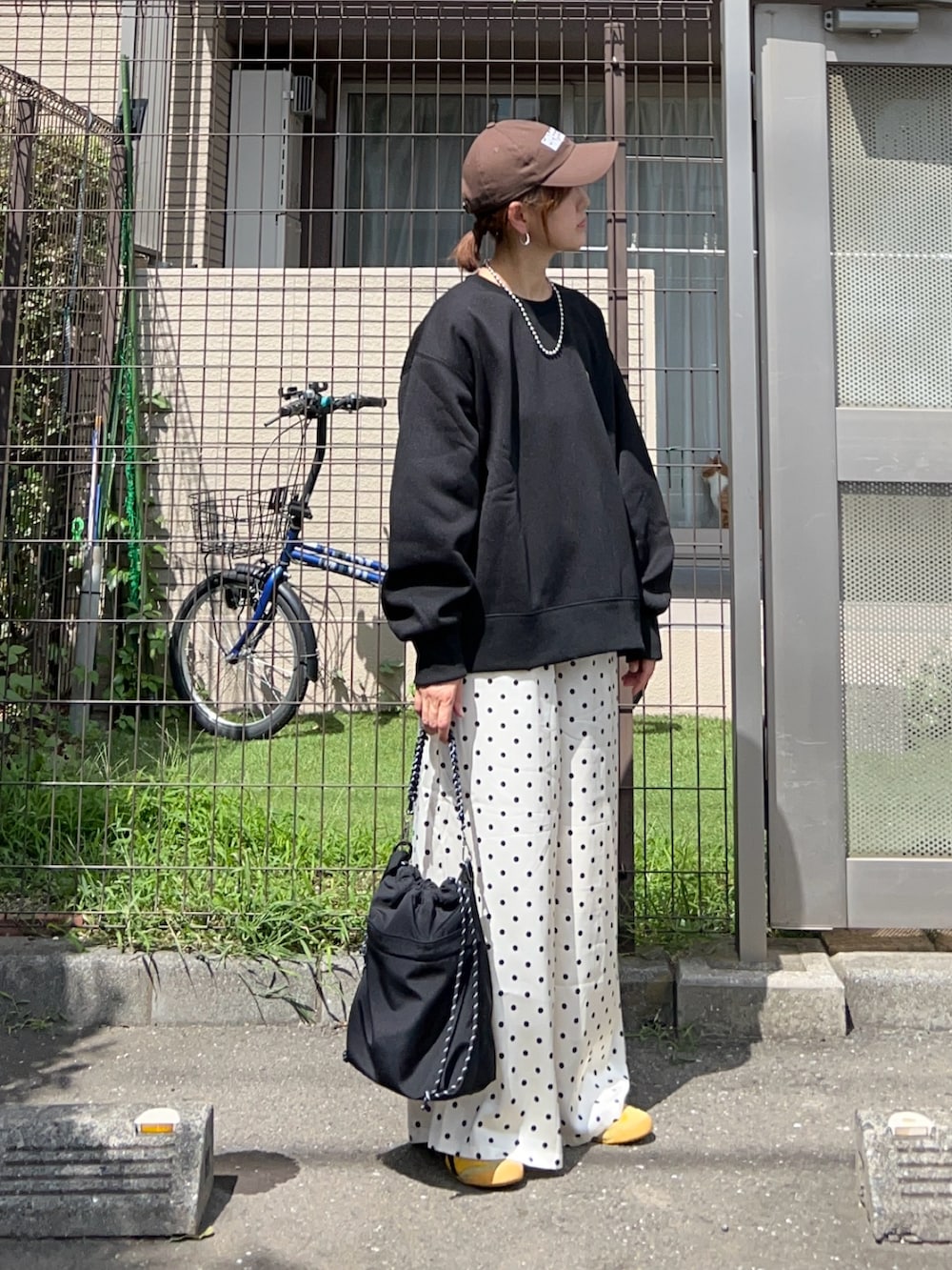 ブラック系のスウェット、ホワイト系のスラックス、ブラック系のトートバッグを着用したレディースの秋コーディネートの2枚目の写真